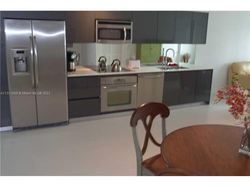 Brickell Miami, FL 33131 - Photo 2 of 14 a kitchen with a refrigerator and cabinets