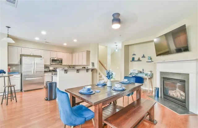 a living room with stainless steel appliances furniture a fireplace and a open kitchen view