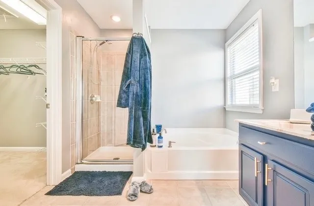 a bathroom with a tub a sink and a window