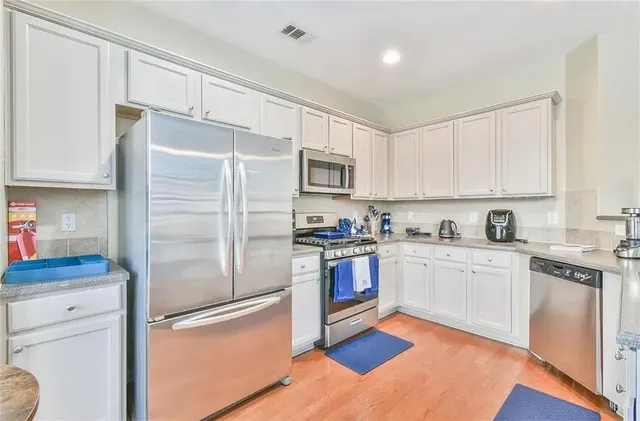 a kitchen with granite countertop stainless steel appliances and wooden cabinets