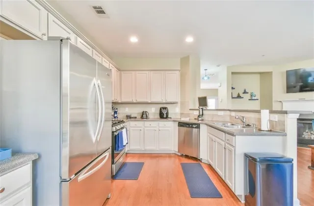 a kitchen with stainless steel appliances granite countertop a refrigerator and a stove top oven
