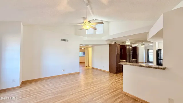 a view of a kitchen with wooden floor and a ceiling fan