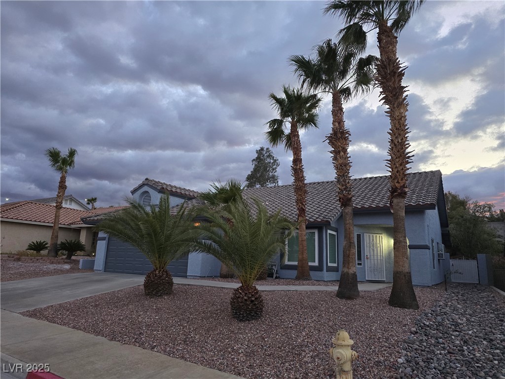 853 Rusty Anchor Way Henderson, NV 89002 - Photo 58 of 76 View of front of house with a tile roof, a garage, driveway, and stucco siding