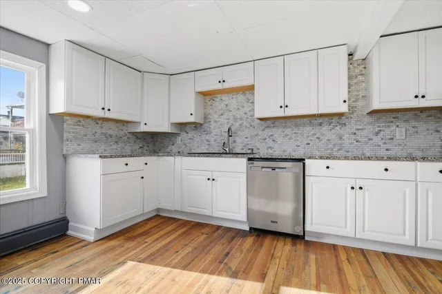 a view of entryway and hall with wooden floor