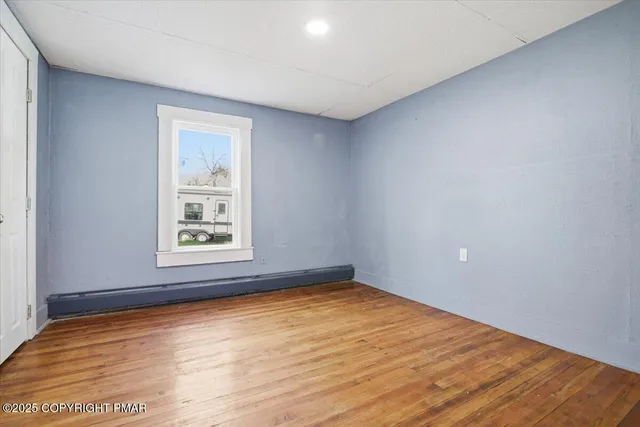 a spacious bedroom with a bed and a painting on the wall