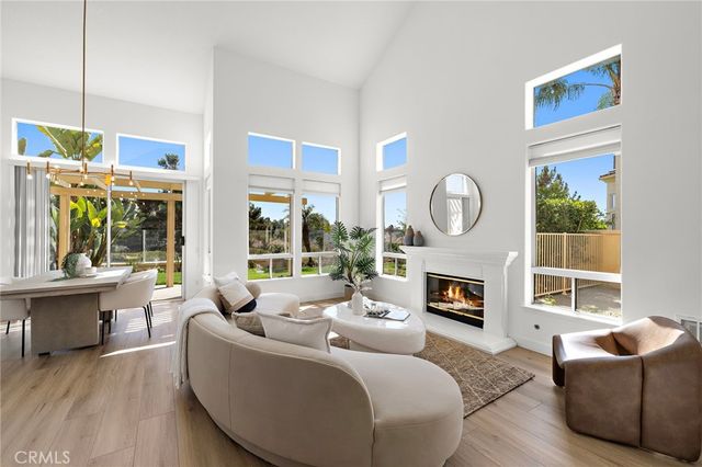 a living room with furniture a fireplace a large window and a large window