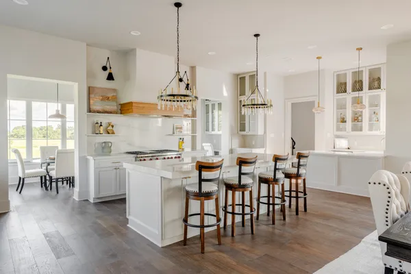 a kitchen with white cabinets and window