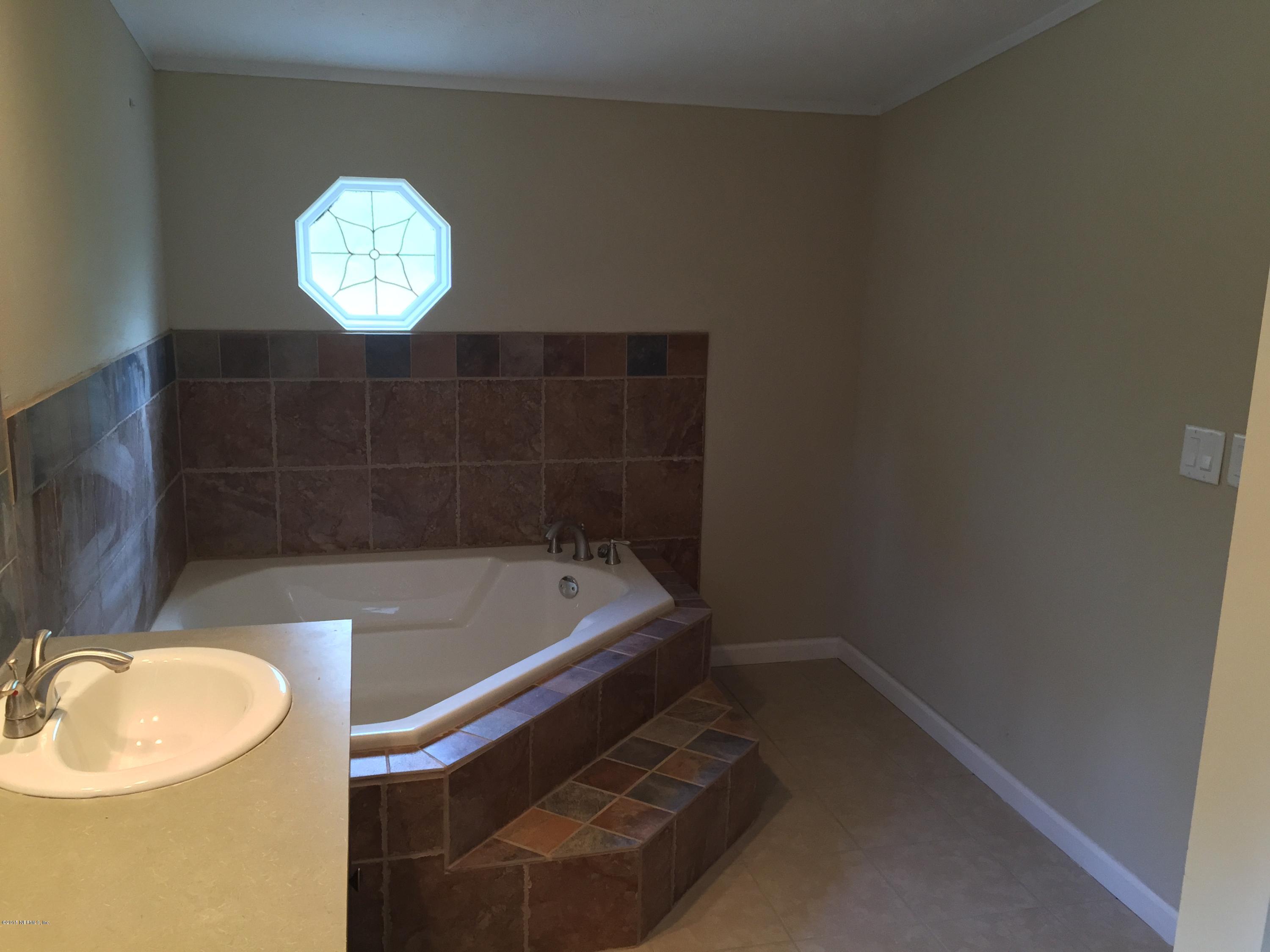 4653 Calendula Avenue Middleburg, FL 32068 - Photo 14 of 50 a bathroom with a sink a bathtub and a window