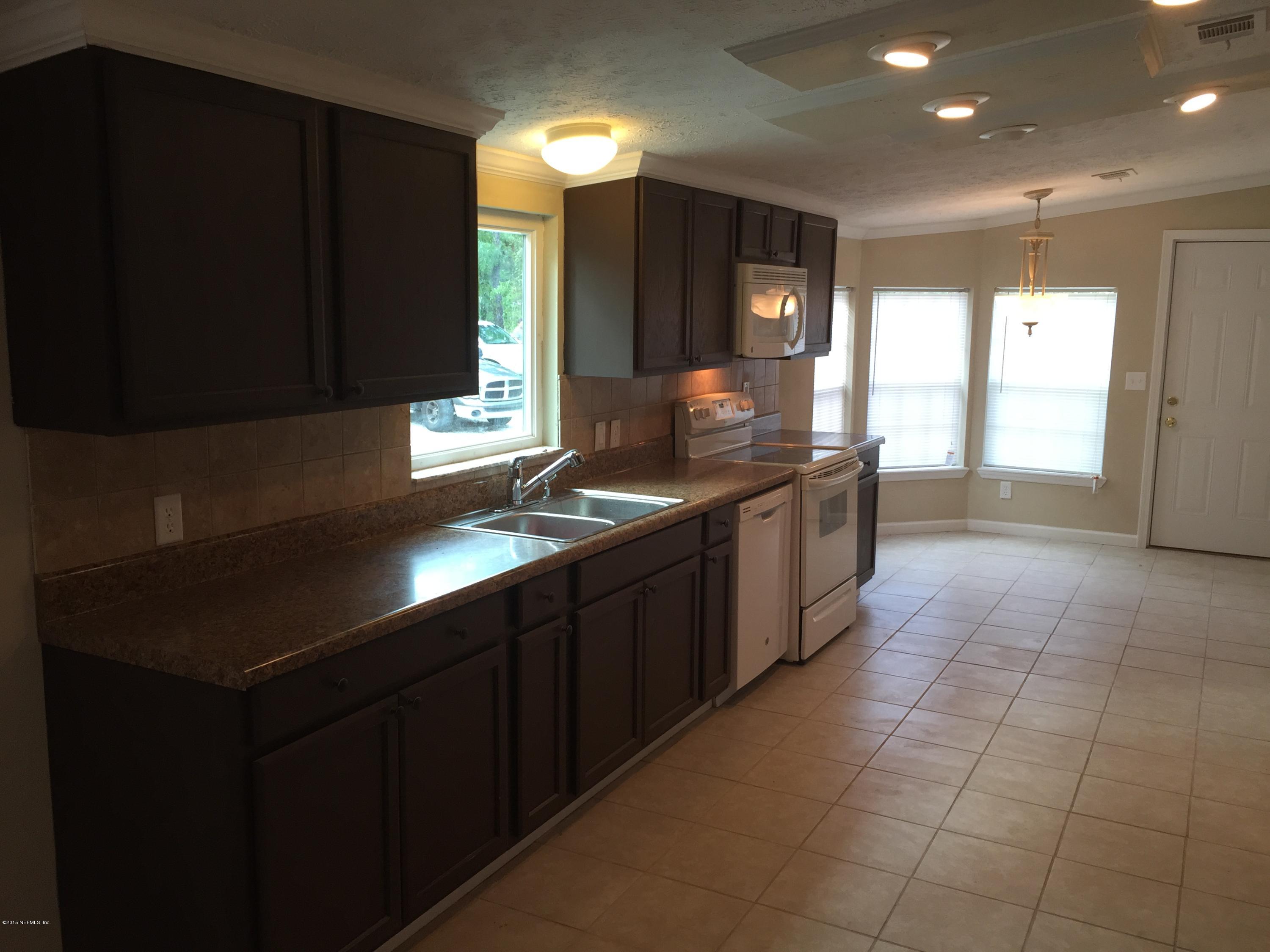 4653 Calendula Avenue Middleburg, FL 32068 - Photo 20 of 50 a kitchen with stainless steel appliances a sink stove and cabinets