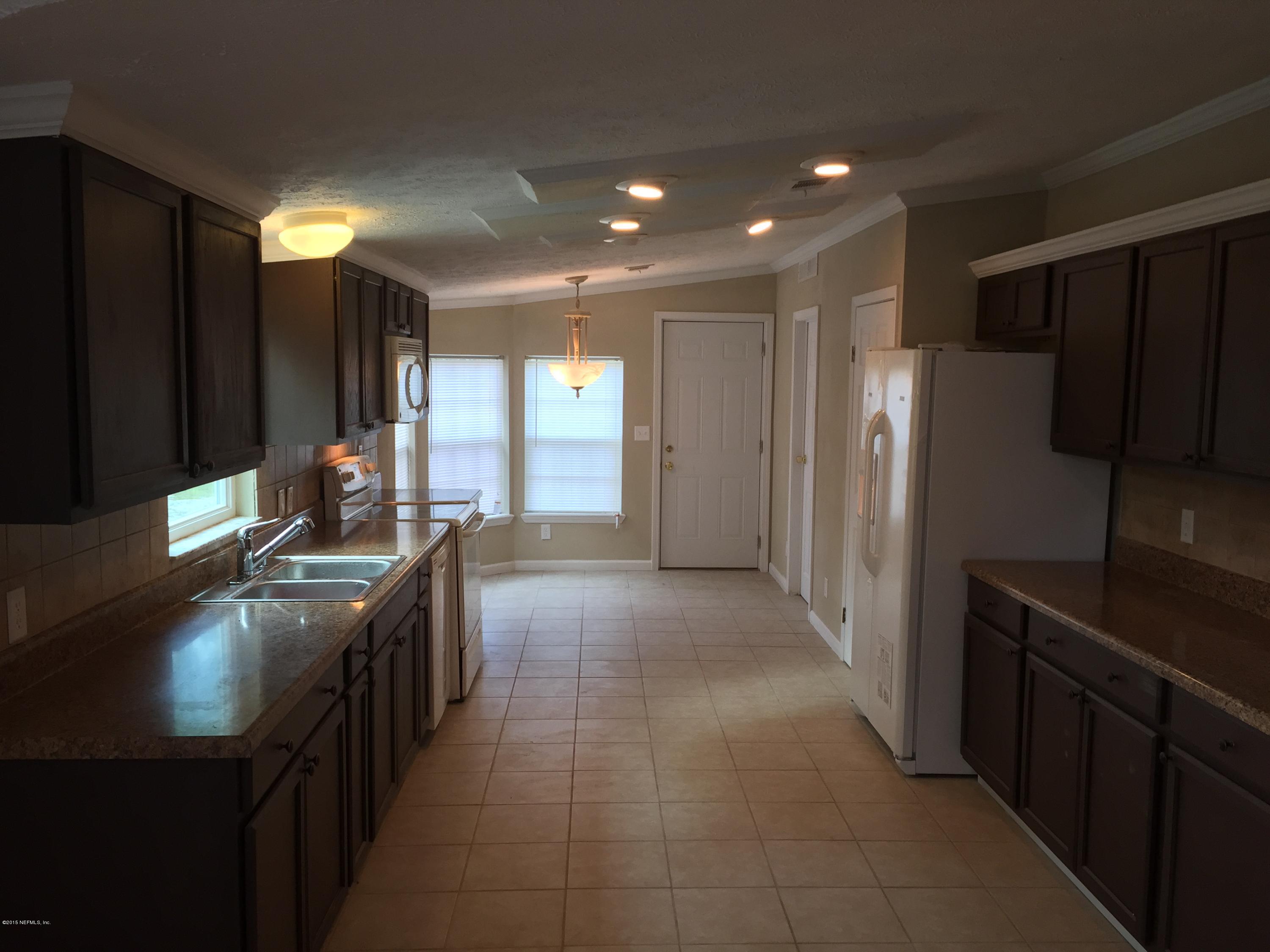 4653 Calendula Avenue Middleburg, FL 32068 - Photo 21 of 50 a kitchen with stainless steel appliances granite countertop a refrigerator and a sink