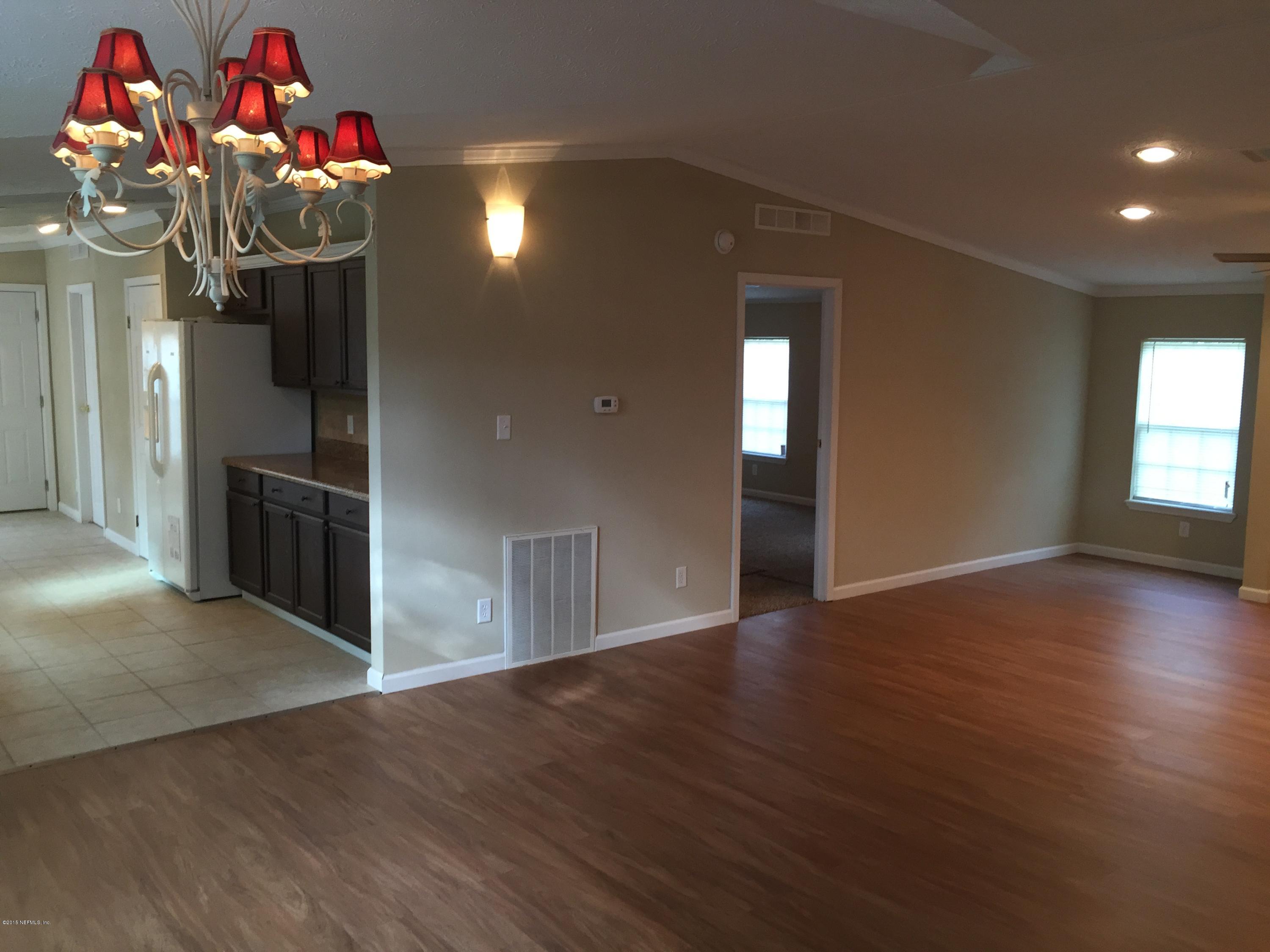4653 Calendula Avenue Middleburg, FL 32068 - Photo 25 of 50 an empty room with wooden floor and hallway