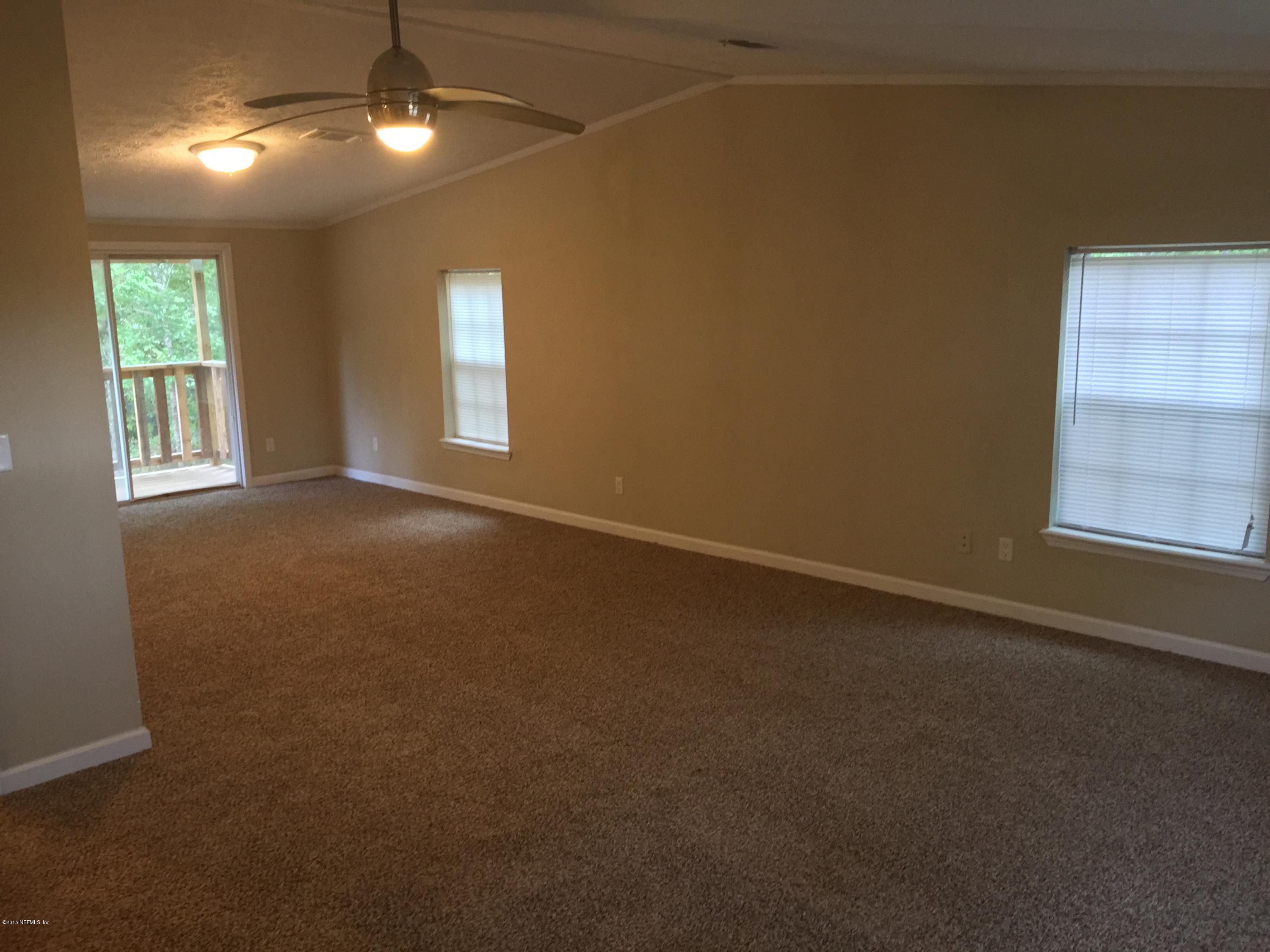 4653 Calendula Avenue Middleburg, FL 32068 - Photo 45 of 50 an empty room with windows and chandelier fan