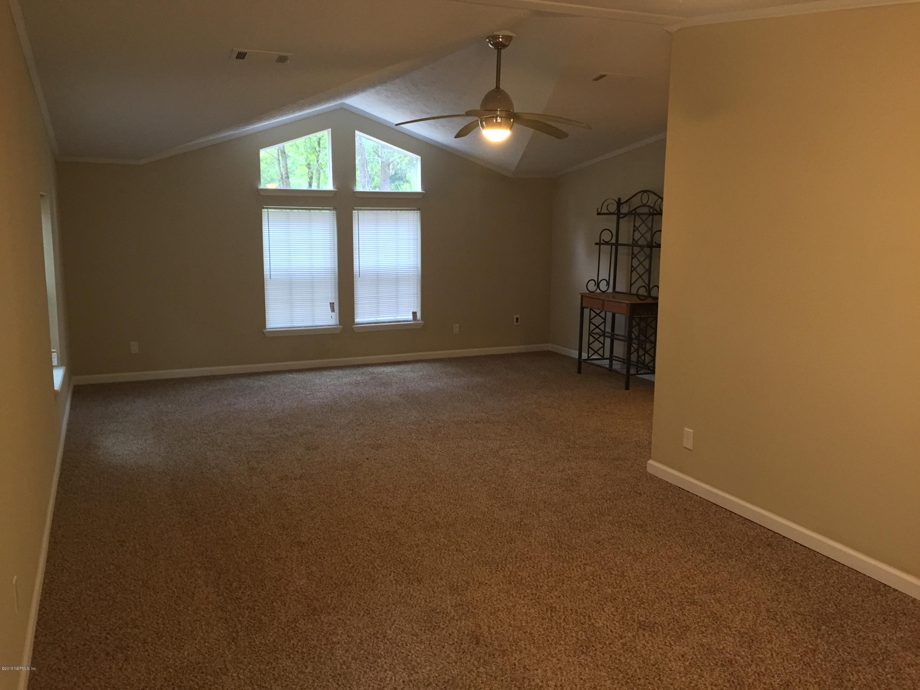 4653 Calendula Avenue Middleburg, FL 32068 - Photo 47 of 50 en empty room with windows and chandelier fan