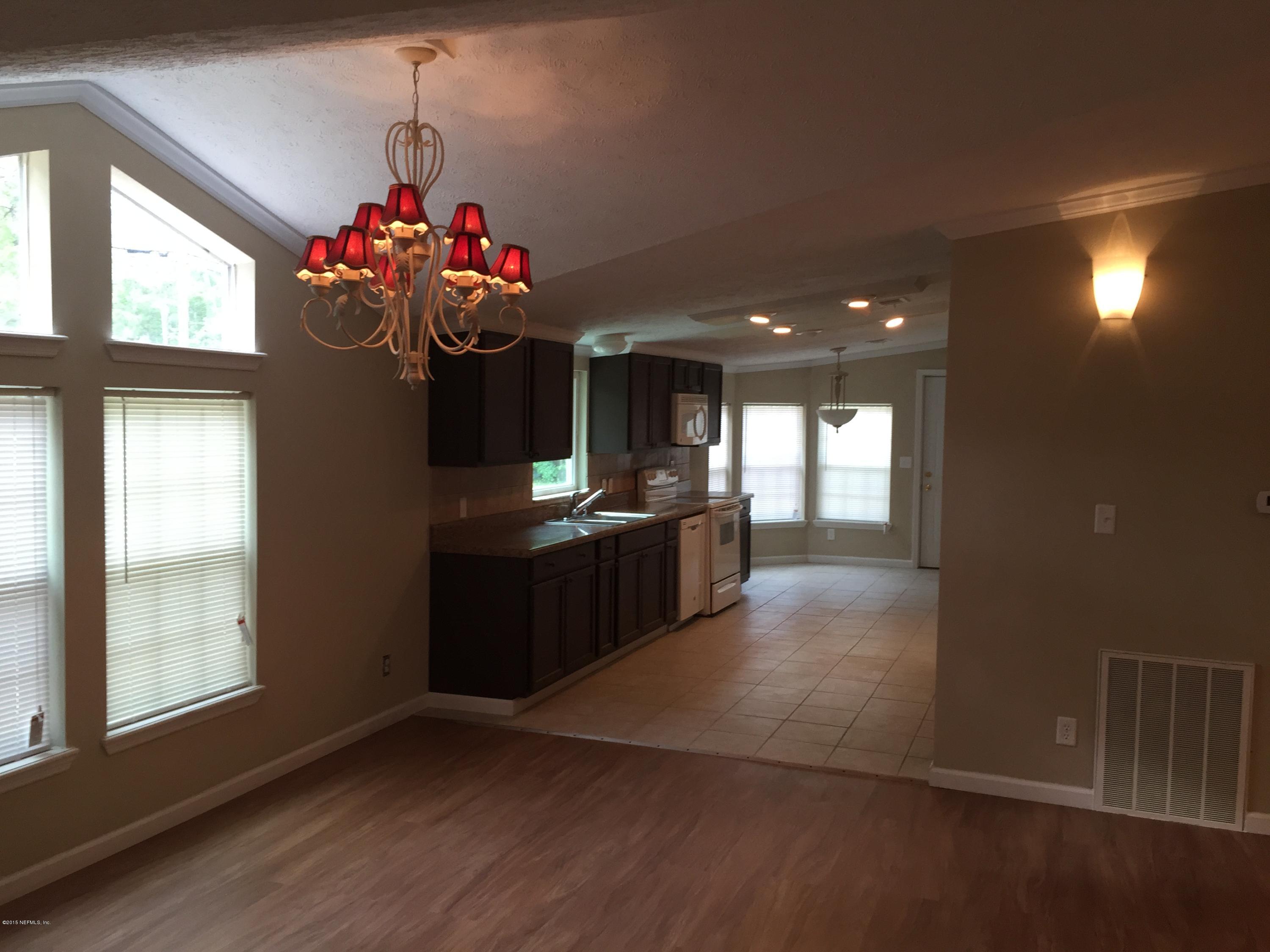 4653 Calendula Avenue Middleburg, FL 32068 - Photo 50 of 50 a kitchen with kitchen island granite countertop a stove window and cabinets