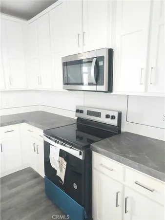 a bathroom with a granite countertop sink toilet and mirror