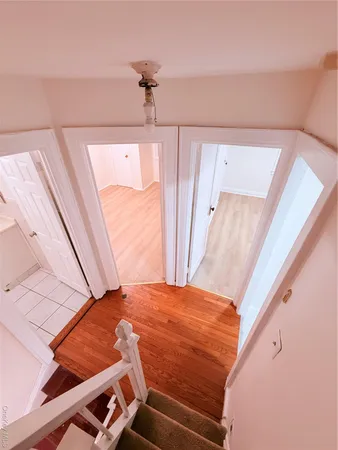 a bedroom with a bed and a large window with wooden floor