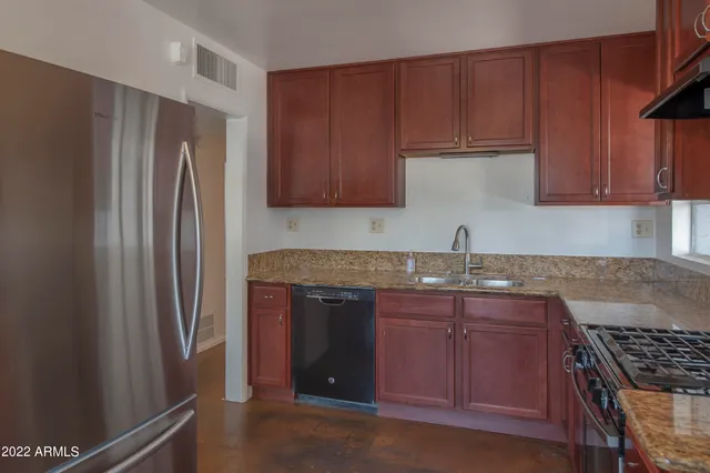 a kitchen with stainless steel appliances granite countertop a refrigerator and a sink
