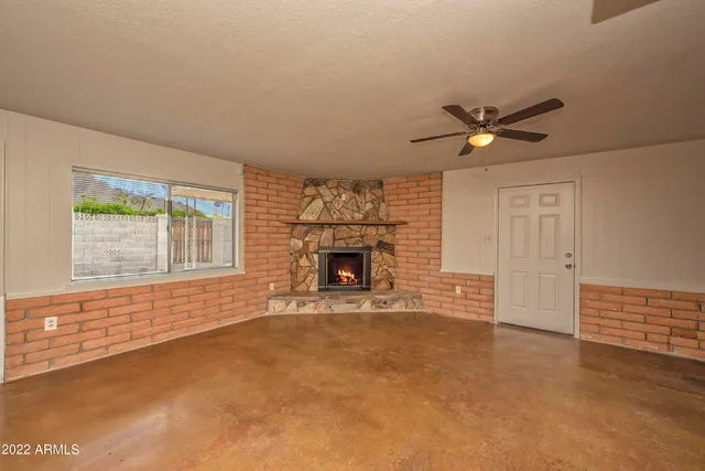 an empty room with a fireplace and fan