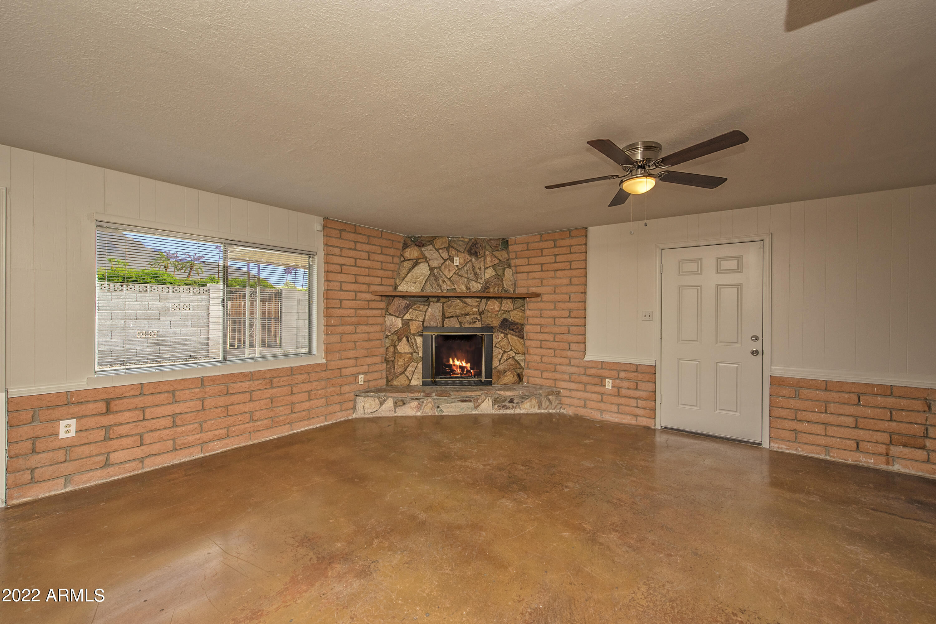 4456 East Campbell Avenue Phoenix, AZ 85018 - Photo 5 of 12 an empty room with a fireplace and fan