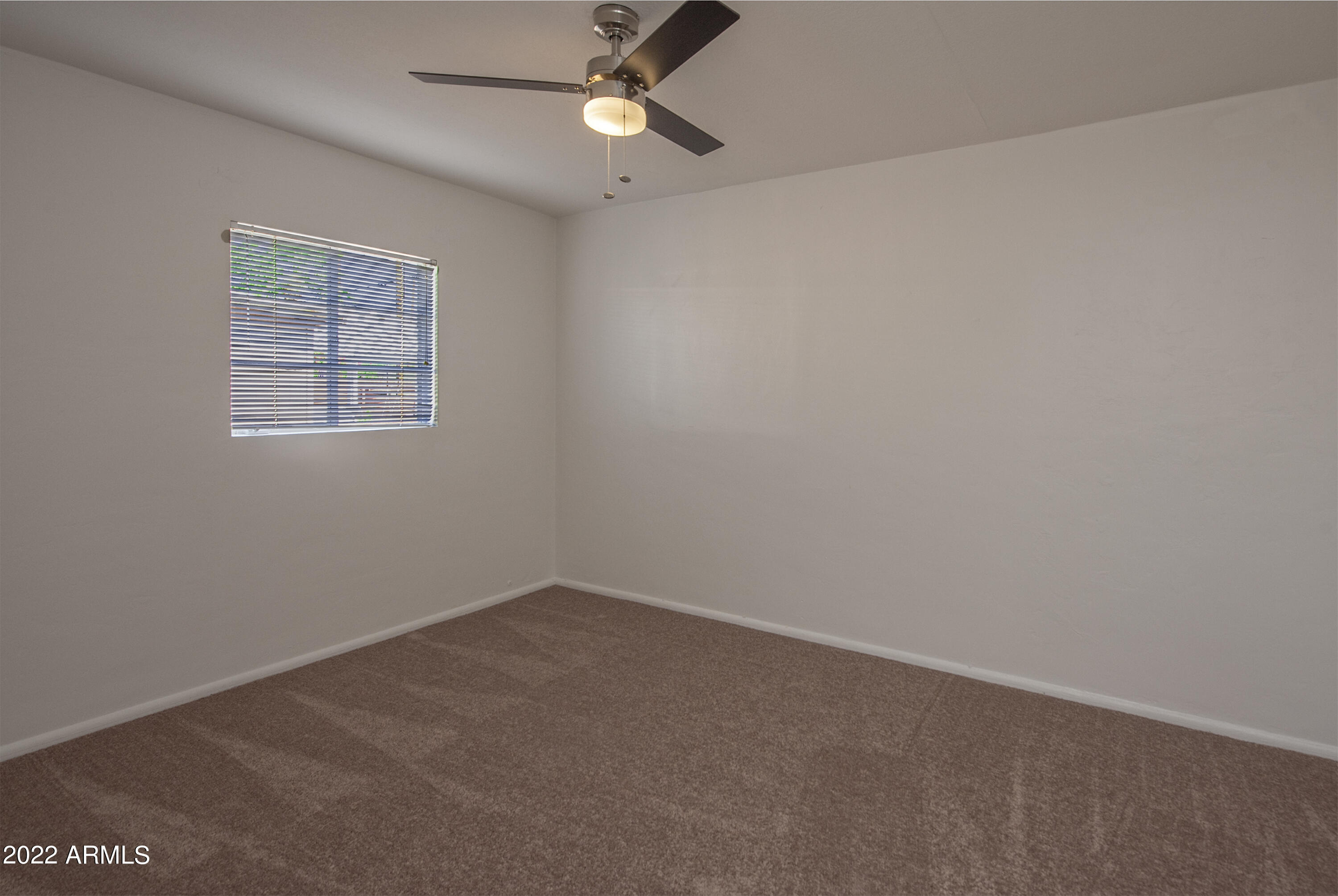4456 East Campbell Avenue Phoenix, AZ 85018 - Photo 10 of 12 an empty room with a window and ceiling fan