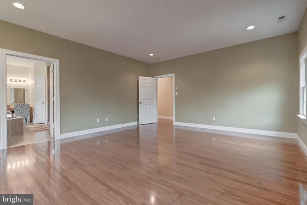 a view of a hallway with wooden floor and stairs