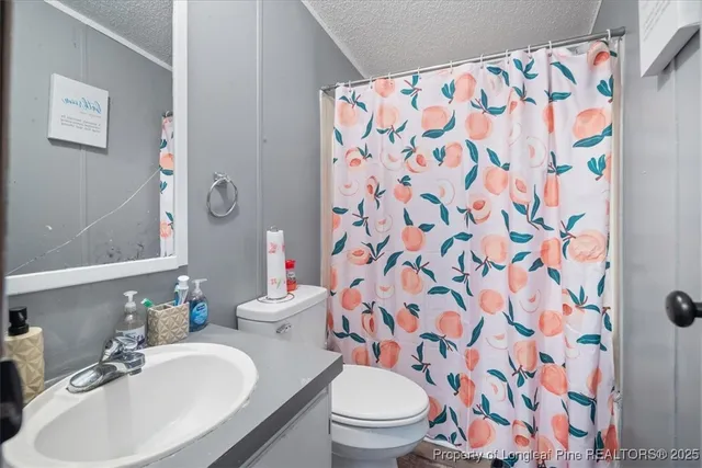a bathroom with a sink and mirror with toilet