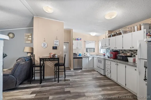 a kitchen with white cabinets and counter space