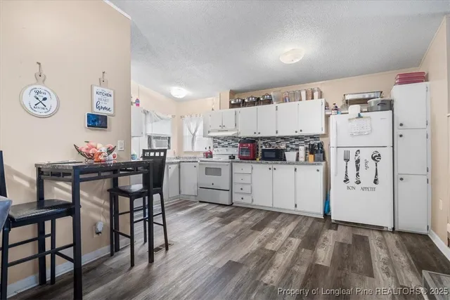 a kitchen with cabinets and wooden floor