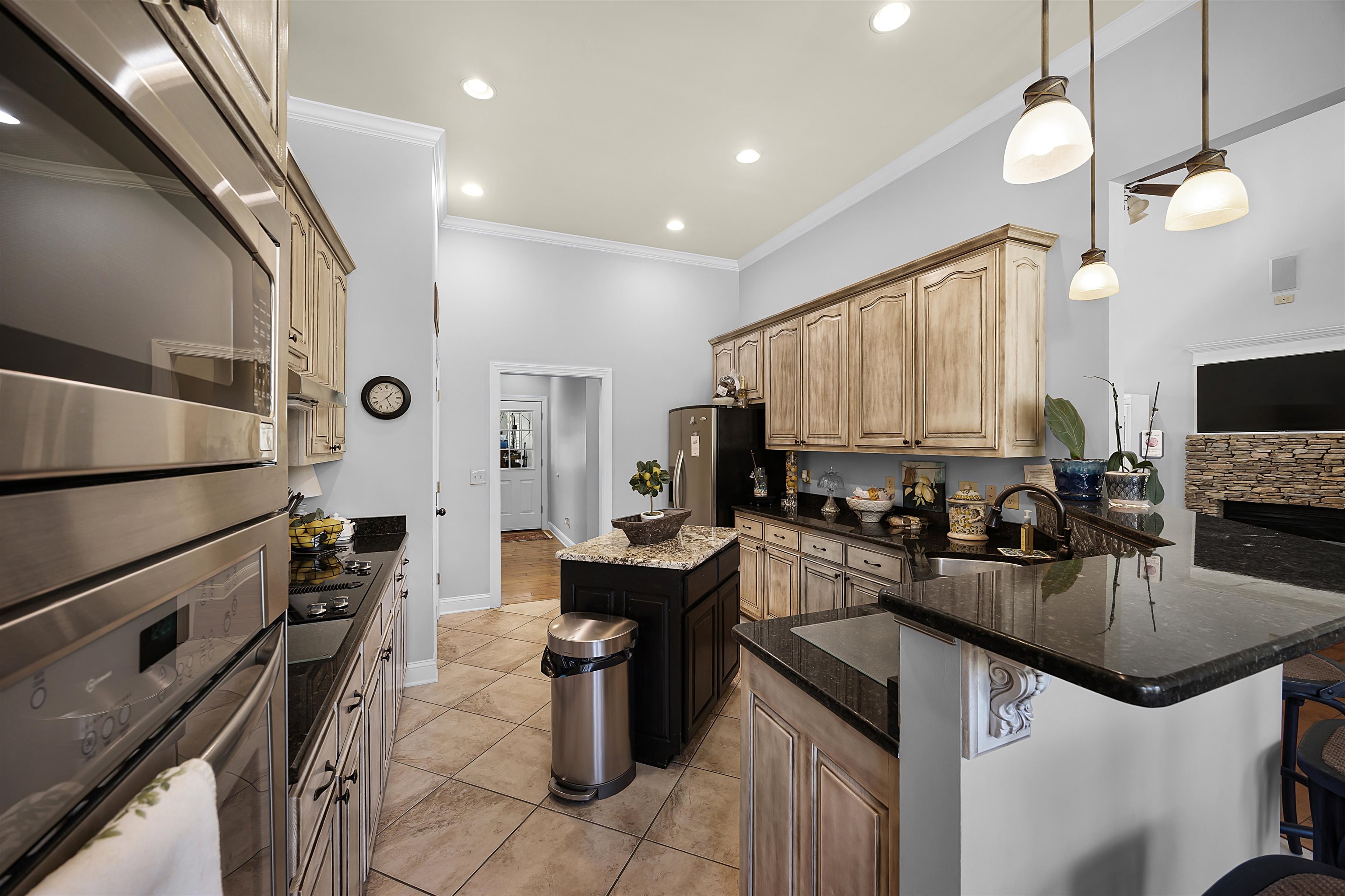 140 Legends Drive Counce, TN 38326 - Photo 9 of 30 Kitchen featuring appliances with stainless steel finishes, dark stone counters, decorative light fixtures, crown molding, and a breakfast bar area