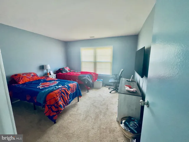 a bedroom with two beds and a window