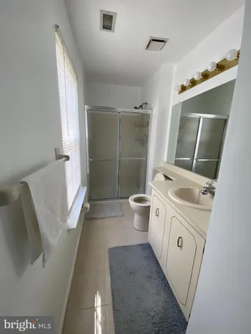 a spacious bathroom with a double vanity sink a toilet and a shower