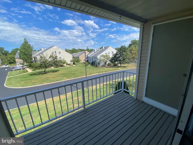 a view of balcony with wooden floor & fence