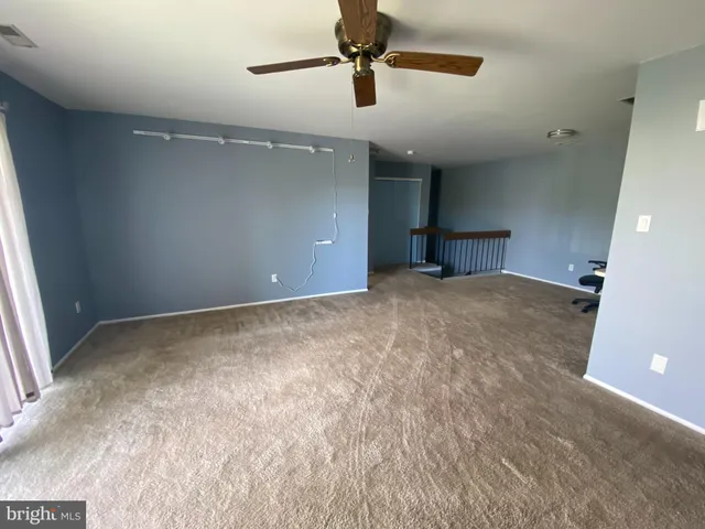 en empty room with windows and fan