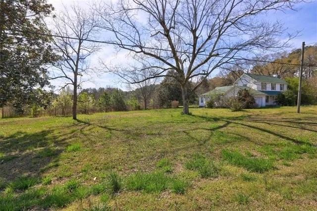 a view of a house with a yard and large tree