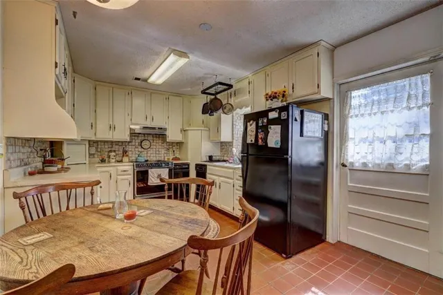 a kitchen with cabinets and chairs