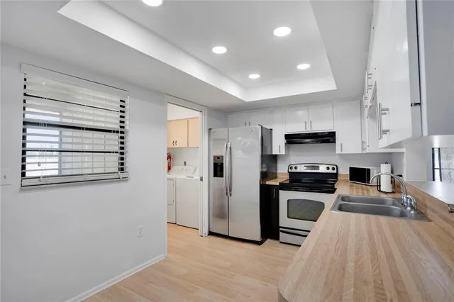 a kitchen with stainless steel appliances a stove a refrigerator and a sink