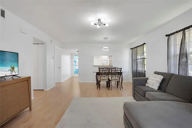 a living room with furniture dining area and a chandelier