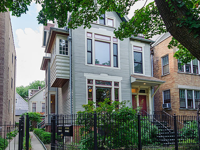 1429 West Roscoe Street Chicago, IL 60657 - Photo 1 of 65 a front view of a house with a garden