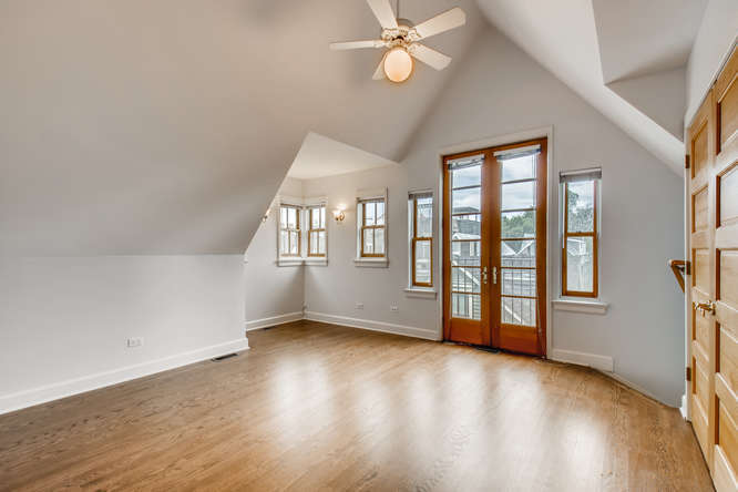 1429 West Roscoe Street Chicago, IL 60657 - Photo 15 of 65 an empty room with wooden floor and windows