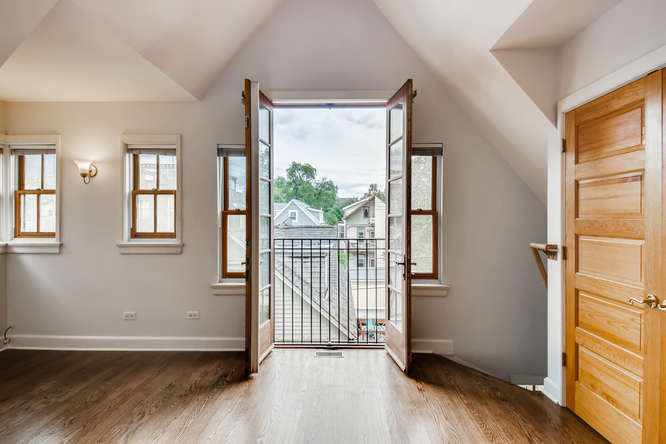 1429 West Roscoe Street Chicago, IL 60657 - Photo 16 of 65 an empty room with wooden floor and windows