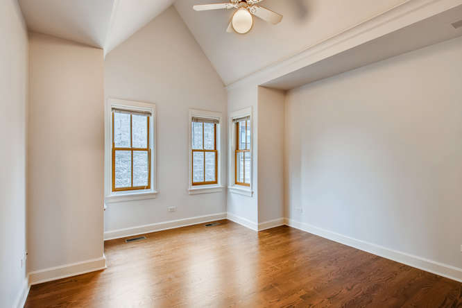 1429 West Roscoe Street Chicago, IL 60657 - Photo 20 of 65 an empty room with wooden floor and windows