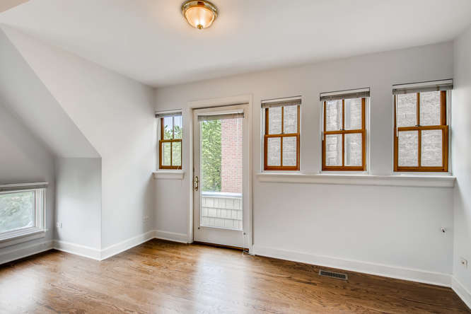 1429 West Roscoe Street Chicago, IL 60657 - Photo 21 of 65 an empty room with wooden floor and windows