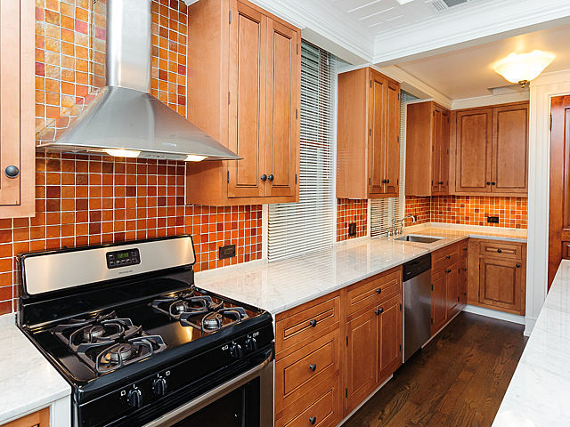 1429 West Roscoe Street Chicago, IL 60657 - Photo 27 of 65 a kitchen with a stove a sink a window and cabinets