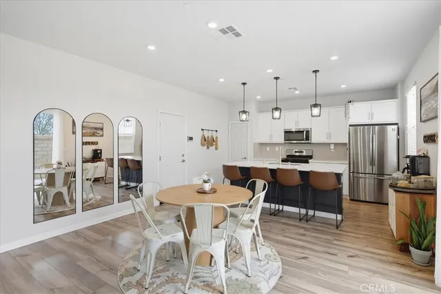 a large kitchen with stainless steel appliances kitchen island granite countertop a table and chairs