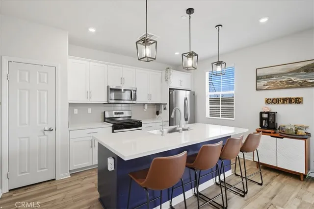 a kitchen with a dining table chairs and white cabinets