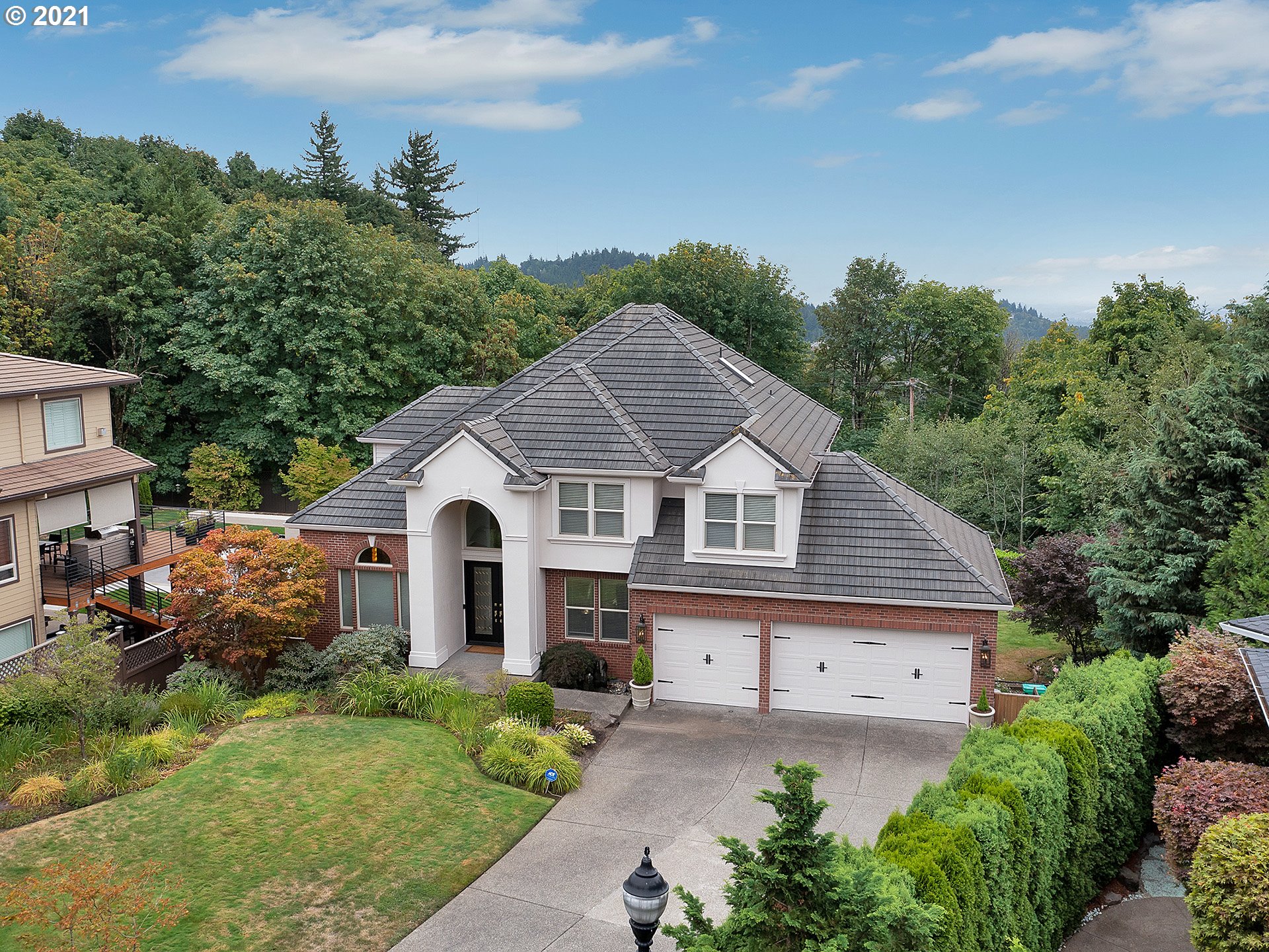 8316 Northwest Ridgetop Court Portland, OR 97229 - Photo 2 of 32 a view of a house with a small yard plants and large tree