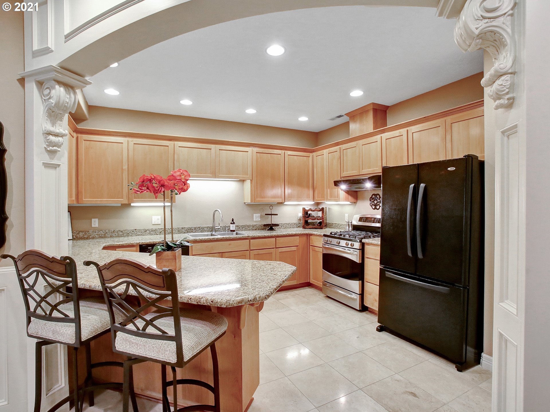 8316 Northwest Ridgetop Court Portland, OR 97229 - Photo 24 of 32 a kitchen with a table chairs refrigerator and microwave