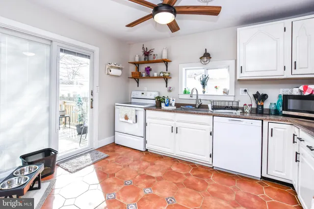 a kitchen with white cabinets and appliances