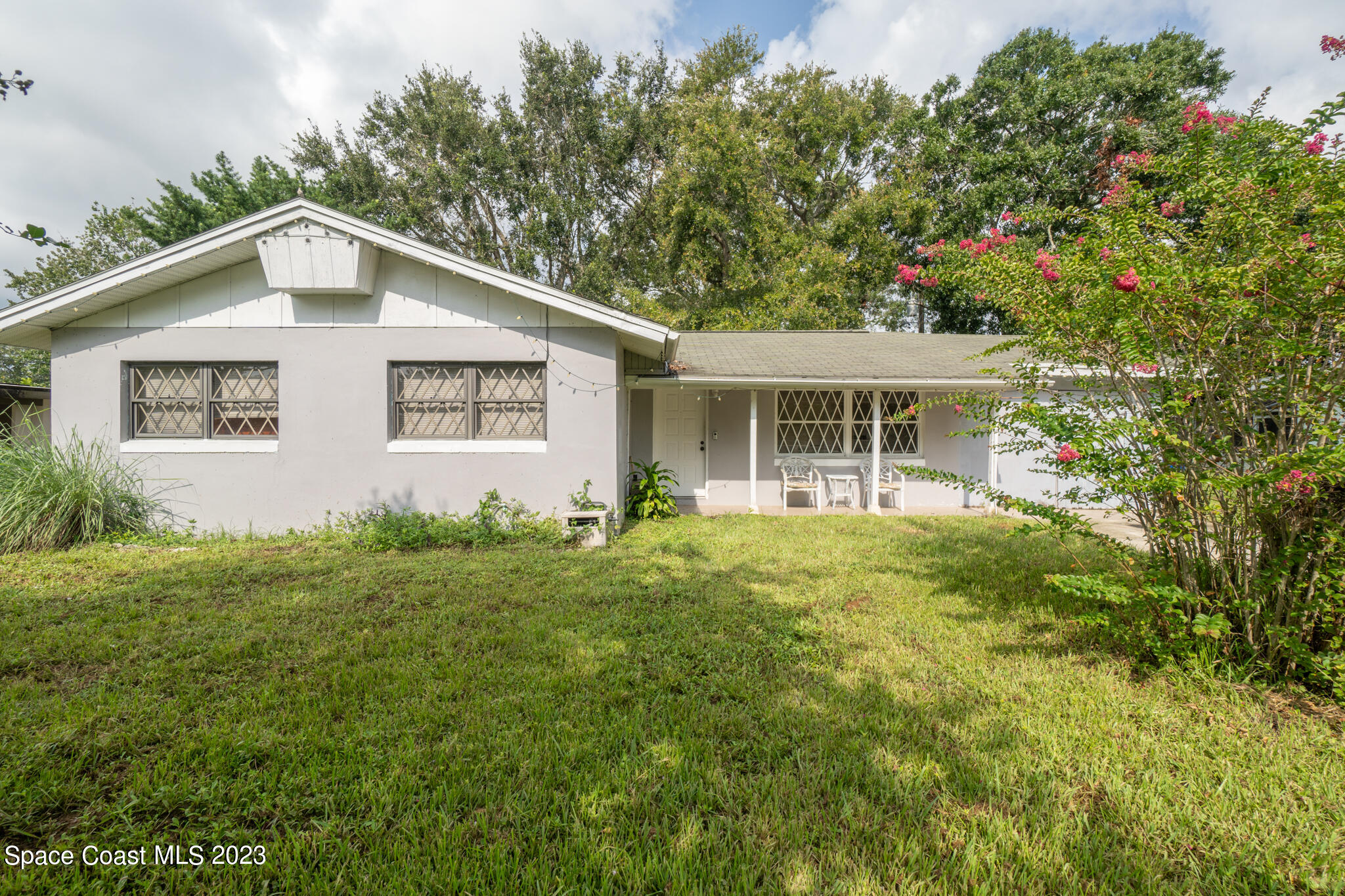 265 Lee Road Melbourne, FL 32904 - Photo 1 of 10 a view of a yard in front of a house with plants and large tree