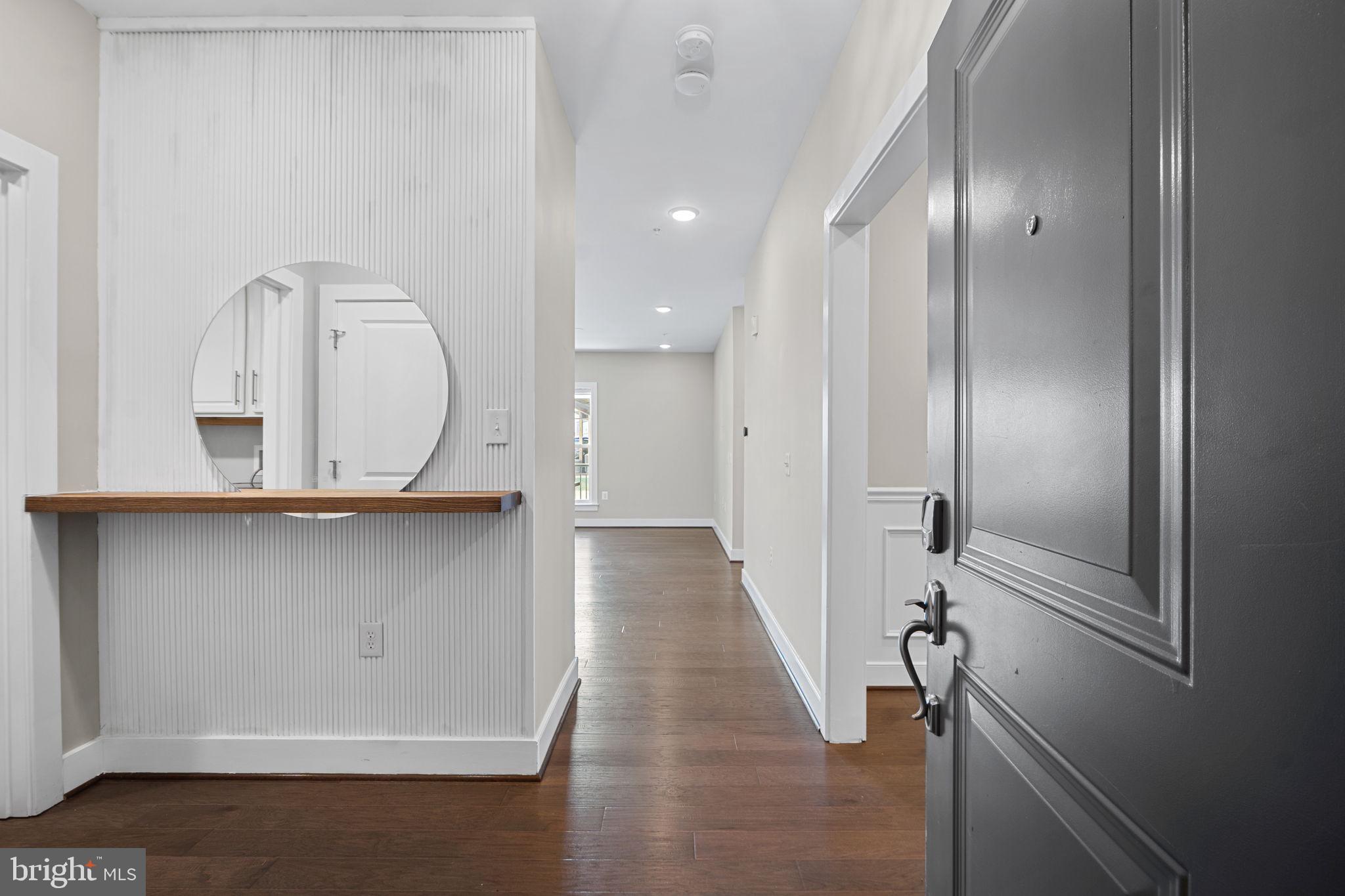wooden floor with view of bathroom